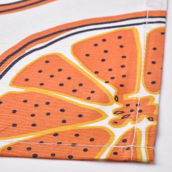 Brightly colored tablecloth with orange, yellow, and black dots, showcasing vibrant, playful design.