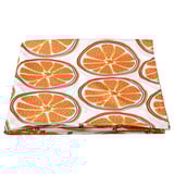 Folded orange slice pattern tablecloth, vibrant on white, recycled polyester material.