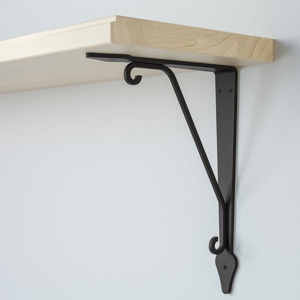 Wooden shelf mounted with black metal bracket, securely attached to wall, displaying simple & sturdy design.