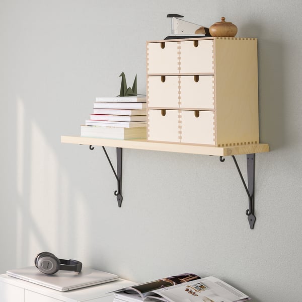 Wall-mounted wooden shelf holds books and decorative items, freeing floor space.