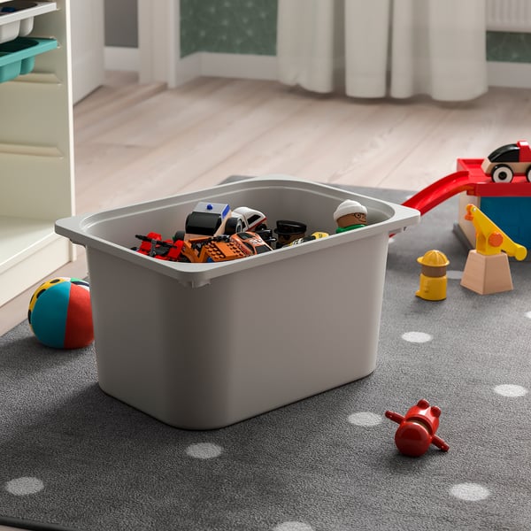 A grey TROFAST storage box holds toys, great for organizing childrens rooms. It fits in frames and can stack with a lid.