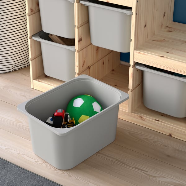 Storage bin on wooden floor, holding toys.