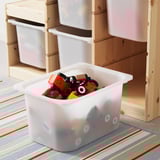 A toy storage bin with a wooden frame, holding several plastic boxes. One box is in front, filled with colorful toys.