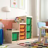 TROFAST storage: light wood, green & orange boxes, large, colorful, with several compartments. Tall unit with blue chair, fitting playful room.