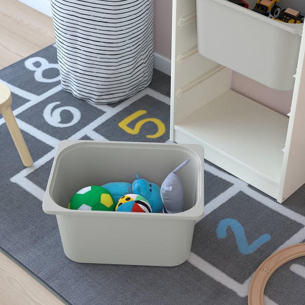 Image shows a TROFAST toy storage unit with colorful toys in a gray bin, demonstrating easy access and organization.