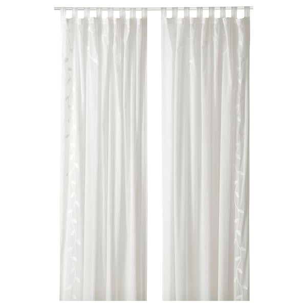 Two white sheer curtains hang straight, with subtle leaf patterns, offering privacy while letting light through.