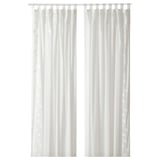 Two white sheer curtains hang straight, with subtle leaf patterns, offering privacy while letting light through.