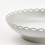 Elegant white candle holder with scalloped edge and smooth finish, showcasing timeless charm and vintage appeal.