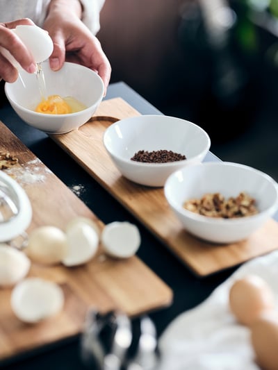 Three white bowls on a light brown bamboo tray; minimalist design, perfect for snacks or dips.