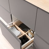Open drawer showing organized items: bottles, cloth.