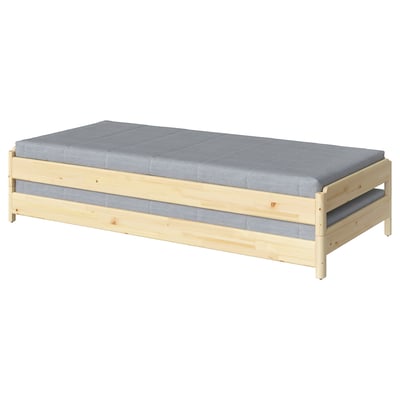 A UTÅKER light wooden bed with a grey mattress. Its rectangular, designed for compact spaces, and stackable for versatility.