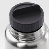 Close-up of durable, stainless steel travel mug lid, designed for no-spill pouring and secure closure.