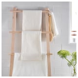 Wooden ladder towel holder with white textured towels, easy to coordinate bath accessories.
