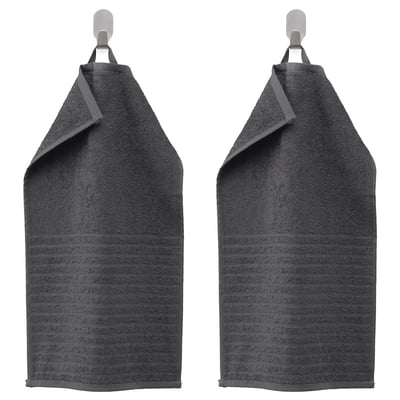Two dark gray VÅGSJÖN towels hang side by side, featuring a striped design with a solid terry texture. Made of 100% cotton.