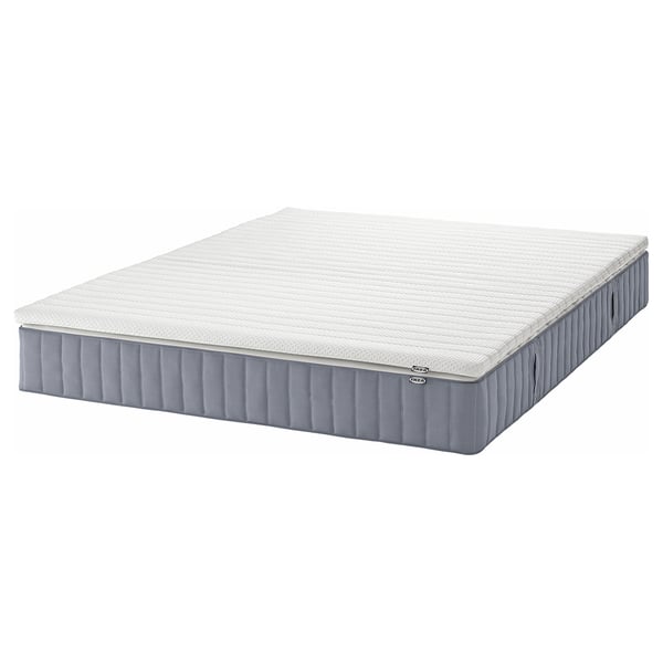 An ikea VALEVÅG rolled mattress in white and gray, designed for firmer support with pocket springs and a removable cover.
