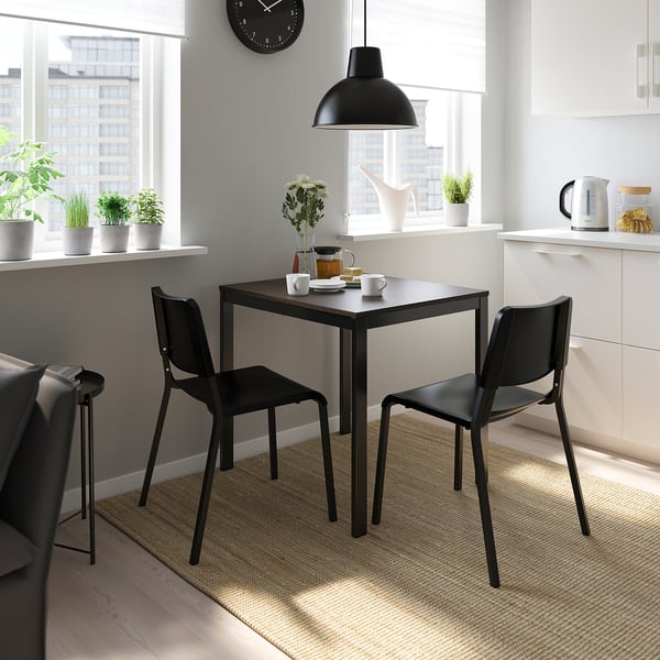 Modern kitchen with VANGSTA table, chairs, and flowers.