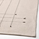 Beige tablecloth with subtle lines and tassels, folded neatly. Made of cotton and jute, showcasing a durable and stylish finish.