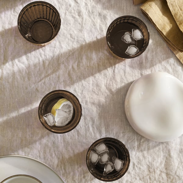 Four VARDAGEN glasses on cloth, three filled with ice, one with lemon. White bowl and cloth beside.
