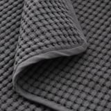 Soft, textured grey cotton blanket folded, showcasing its plush, inviting weave.