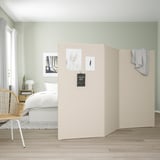 Room divider with photos and notes, separates bedrooms from living space.