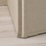 Beige fabric room divider on light wood floor, showcasing sturdy metal base and soft material for sound damping.