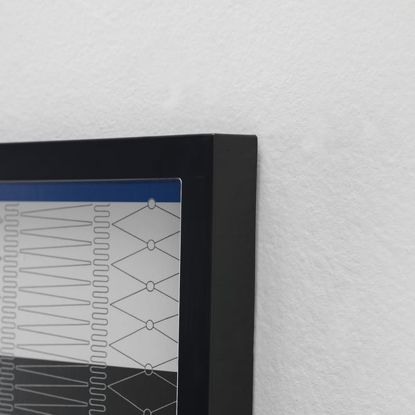 Black-framed photo display mounted on a white wall, showcasing a well-crafted design, emphasizing sleek, modern aesthetics.