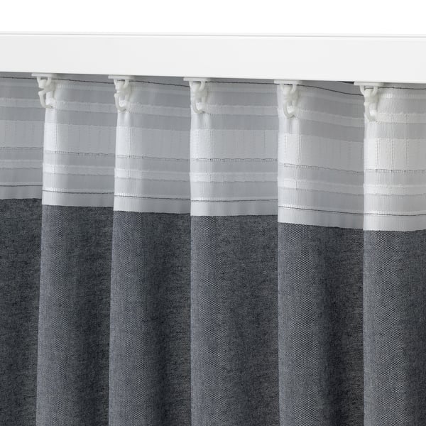 Gray and white striped curtains hang neatly, showcasing quality fabric and even pleats.