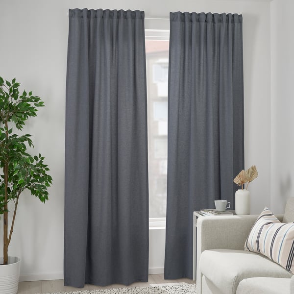 Modern room with gray VÄXELBRUK curtains, white chair, plant, and decor.