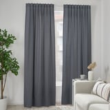 Modern room with gray VÄXELBRUK curtains, white chair, plant, and decor.