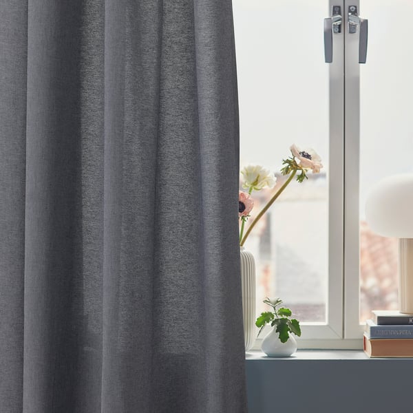 Window with gray VÄXELBRUK curtains, pink flowers in vase.