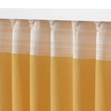 A close-up of textured curtains with a yellow and beige color scheme, hanging neatly with a white curtain rod and hooks.