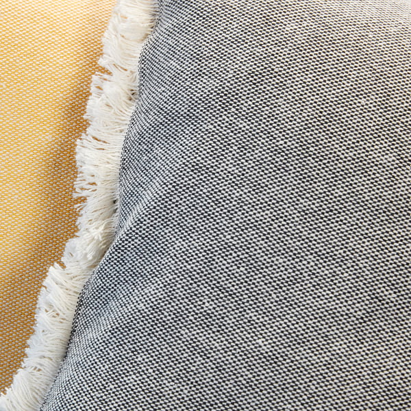 Close-up of woven, textured rug with fringe, gray and white stripes.