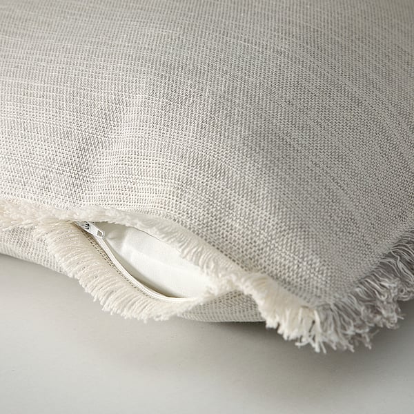 Close-up of recycled cushion cover, soft fabric with gray and white patterns, zipper detail.