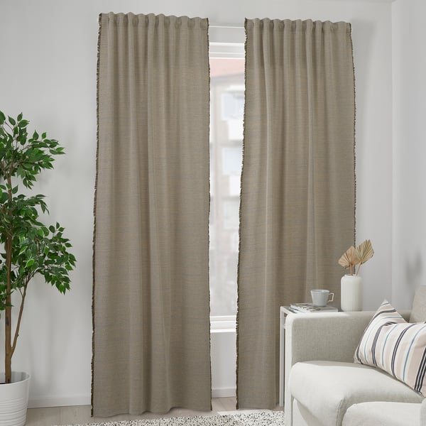 Modern room with recycled gray VÄXELBRUK curtains, large window, white table decor, and striped chair.