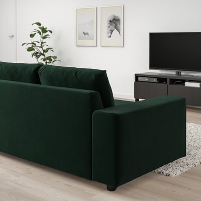 Modern living room with green VIMLE sofa, tv, plant, and wall decor. Sofa has clean lines and dark green colour.