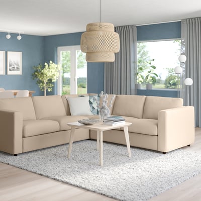 Modern beige VIMLE sectional sofa in living room with coffee table, window, floor lamp, wicker pendant.