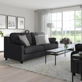 Modern living room with VINLIDEN sofa, art, coffee table, and large windows.