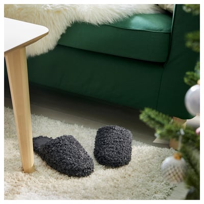Pair of black, textured, cozy slippers with grippy soles, perfect for comfort.