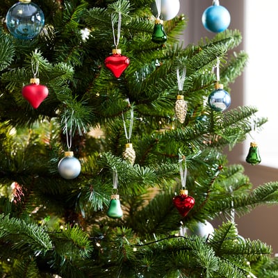 Colorful christmas ornaments in red, green, blue, and gold hues, featuring heart shapes, bells, and lightbulb designs, made of glass and aluminum.