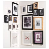 A wall with black, white, and gold picture frames displaying photos and artwork in an attractive layout.
