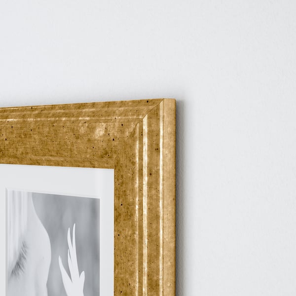 A close-up of a high-quality wooden picture frame on a wall, showcasing its intricate grain and textured finish.