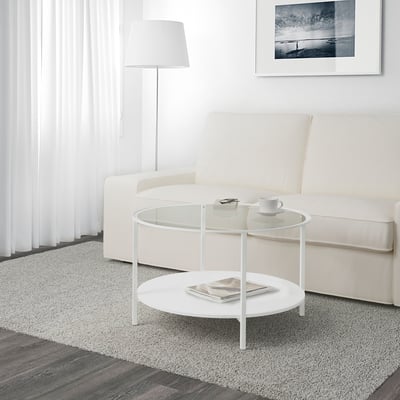 Modern living room with VITTSJÖ glass coffee table, white couch, lamp, and floor rug.