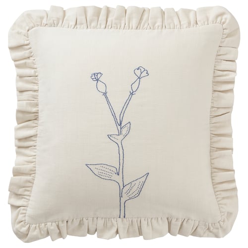 Cojín crema bordado, diseño floral azul, bordes con volantes, material de algodón.