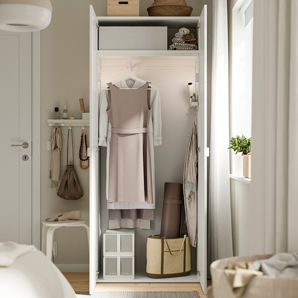 Un armario con ropa, accesorios y soluciones de almacenamiento ordenadas con ganchos, estanterías y un recipiente.