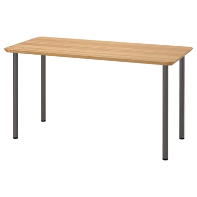 Una mesa ANFALLARE. Su color marrón claro, rectangular, con cuatro patas grises. El diseño es minimalista y moderno.