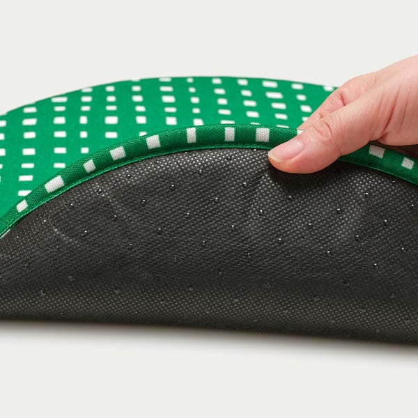 Borde de elevación manual de la almohadilla de silla de lunares verdes y blancos que revela una parte inferior suave y texturizada, que muestra materiales de calidad.