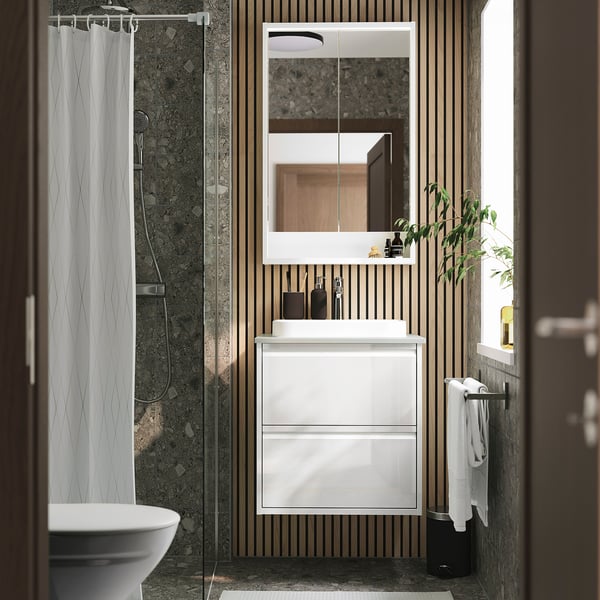 Moderno baño blanco ÄNGSJÖN con elegante lavabo, lavabo de mármol, espejo sin marco y listones de madera.