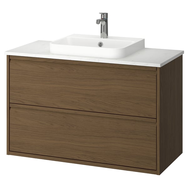 Un moderno mueble de baño de color nogal con encimera y lavabo de cuarzo blanco. Tiene elegantes tiradores de cajón y un diseño minimalista montado en la pared.