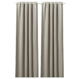 La imagen muestra las cortinas ANNAKAJSA de color gris claro, rectangulares con cinta de cabecera, hechas de poliéster.