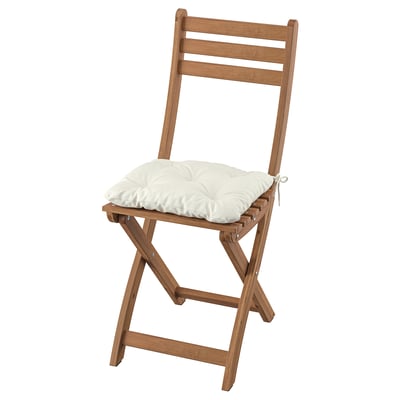 Silla plegable de madera marrón claro con cojín blanco. Diseño clásico, con respaldo de escalera. Perfecto para uso en exteriores.